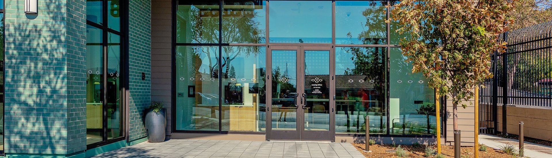 The main entrance to the Legacy at Hayward leasing office, characterized by its large glass doors.