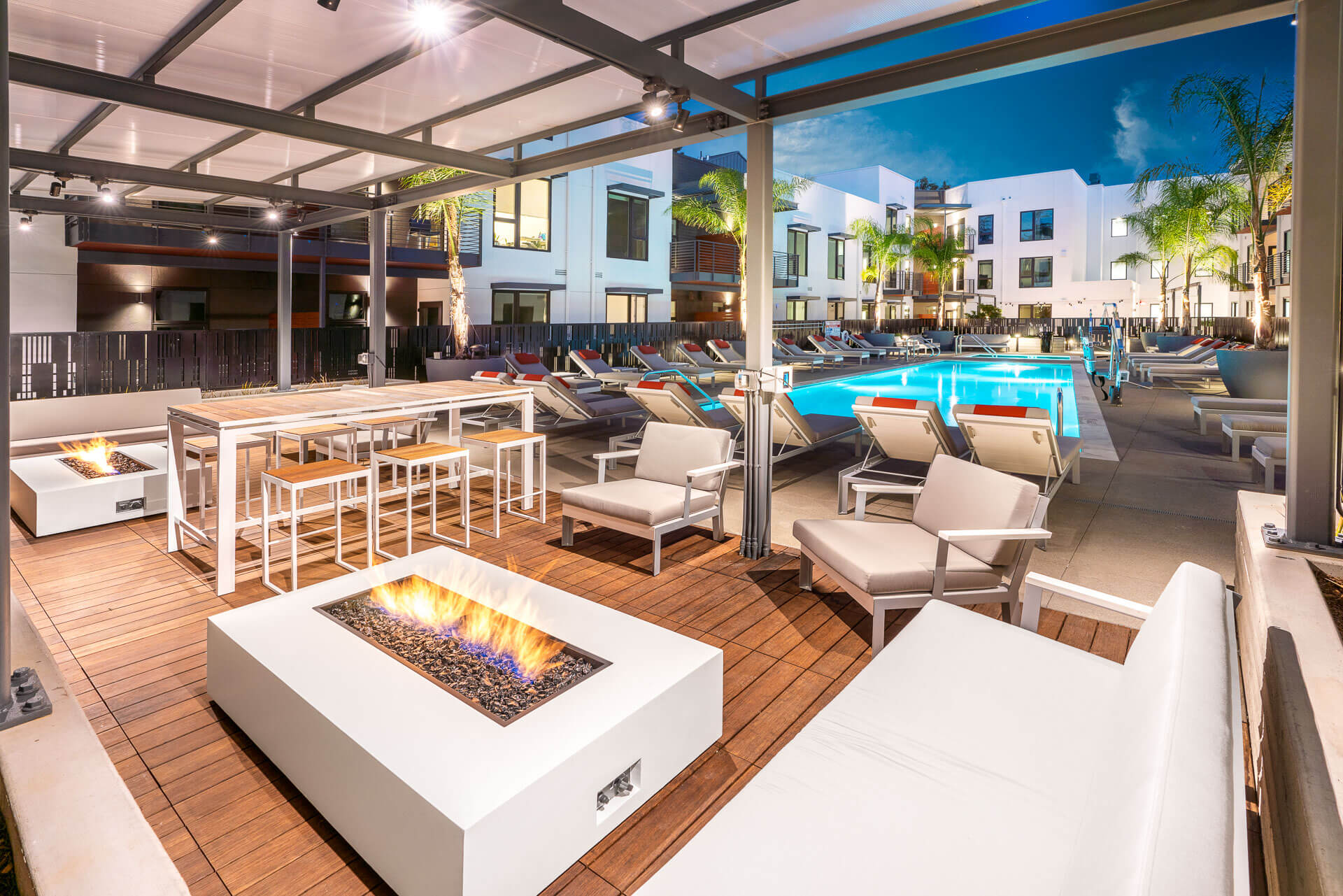 Outdoor pool area featuring dining areas and fire pits for a complete leisure experience